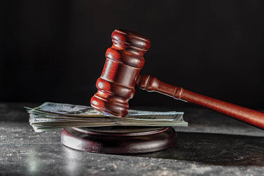 A wooden gavel resting on a stack of US dollar bills