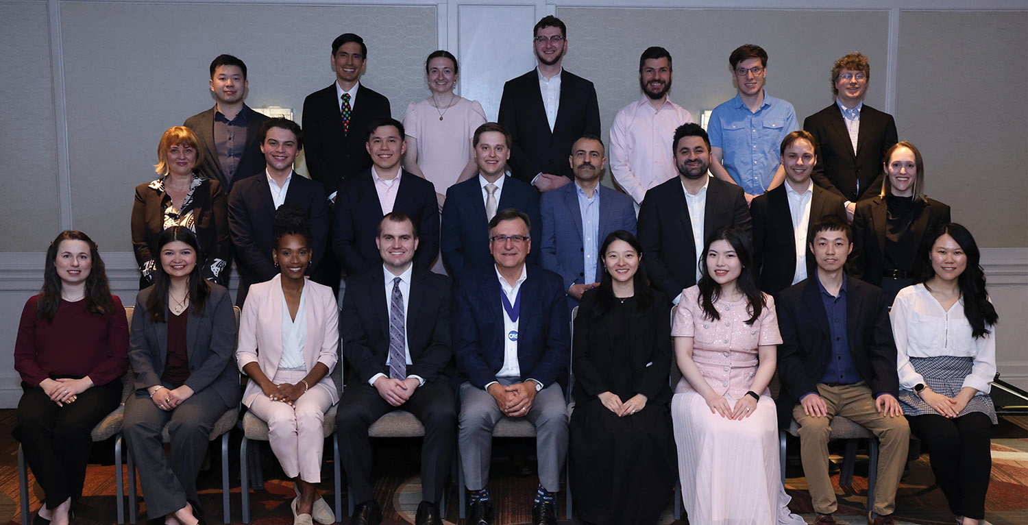 Group portrait of new CAS associates sitting and standing with the CAS President.