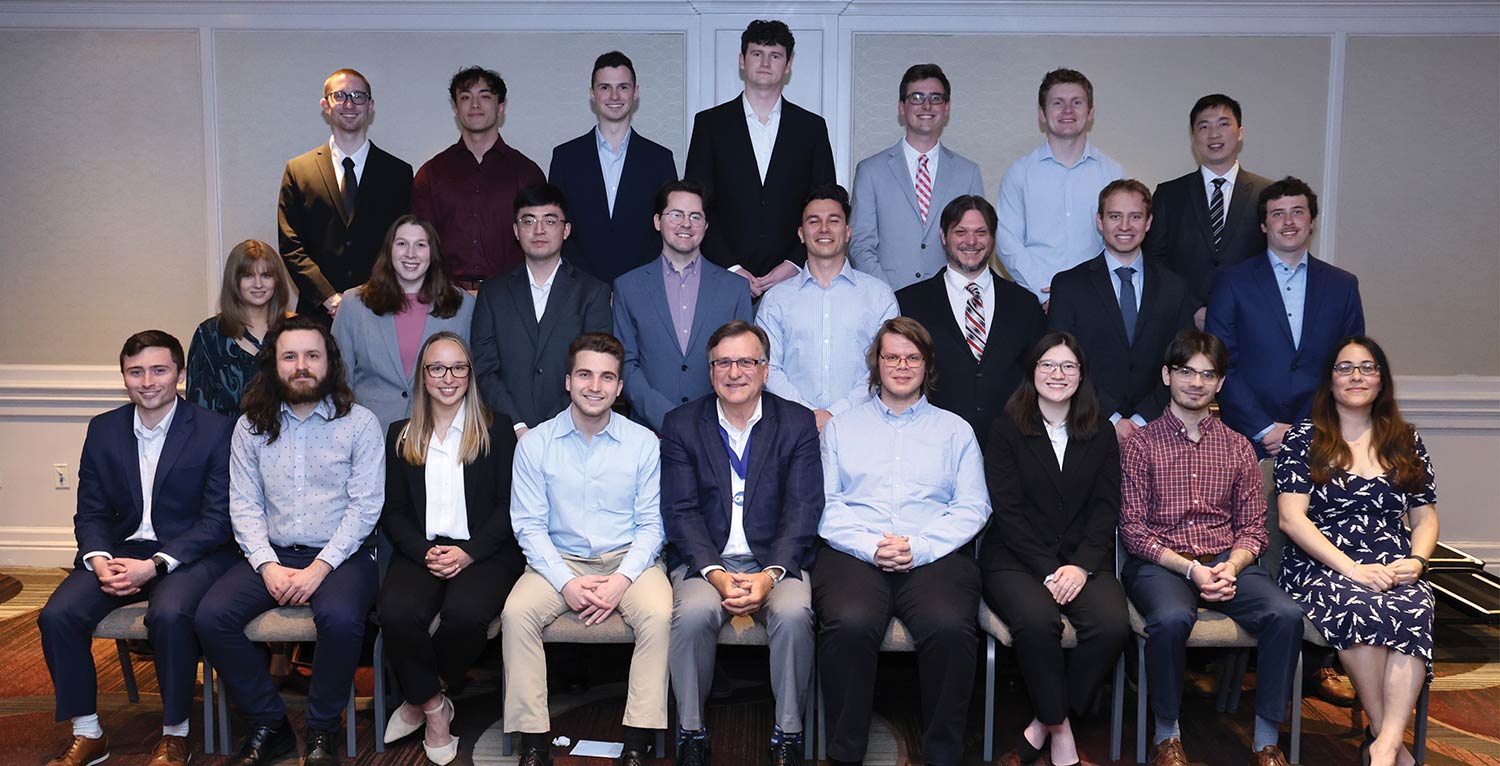 Group photo of new CAS associates posing in rows with the CAS President.