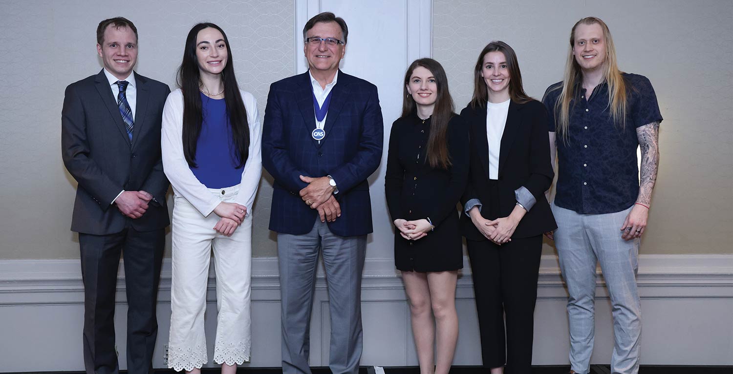 CAS President posing side-by-side with a small group of new associates.