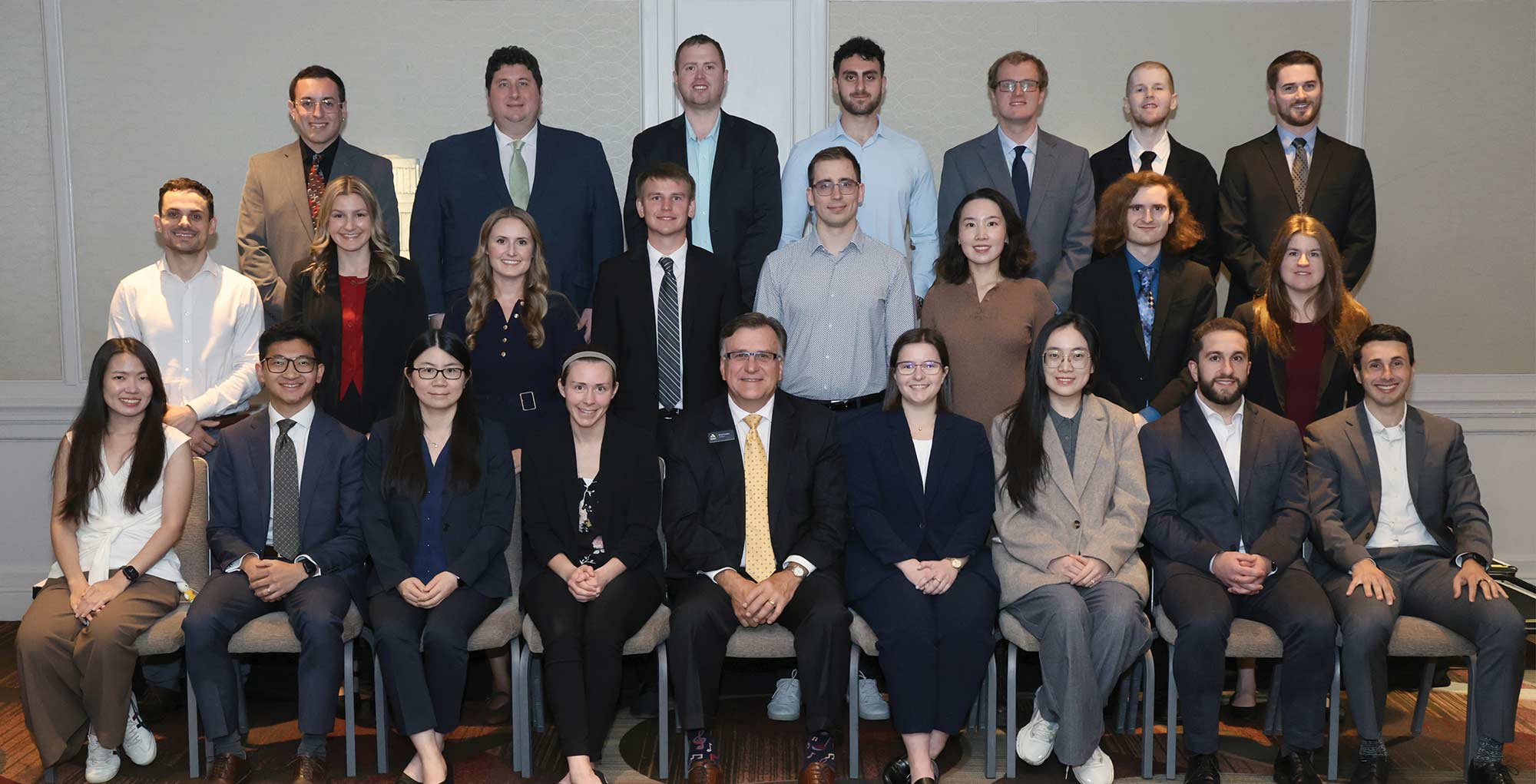 Group portrait of newly credentialed CAS fellows sitting and standing with the CAS President.