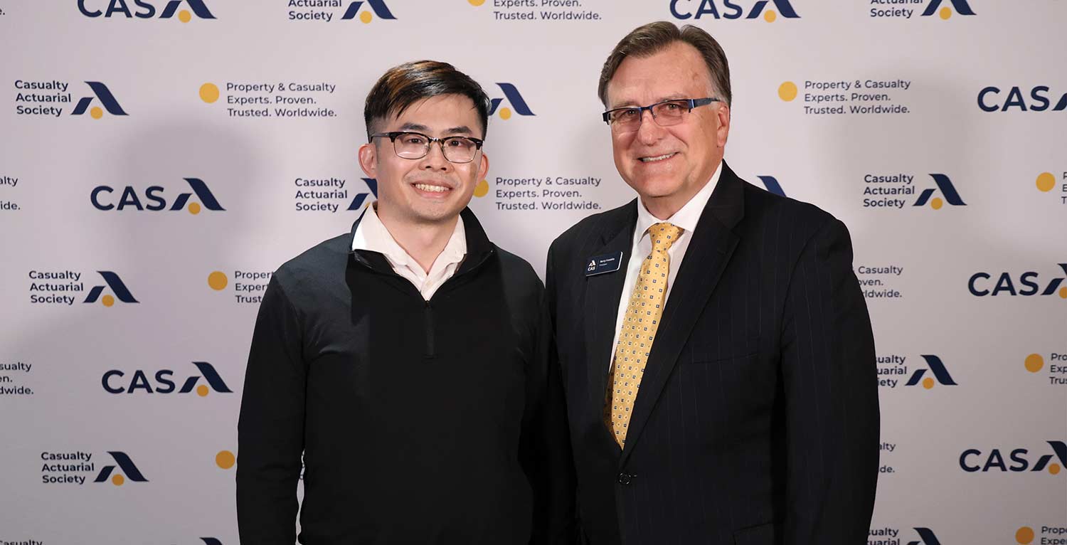 CAS President Barry Franklin posing with a fellow in front of a CAS backdrop.